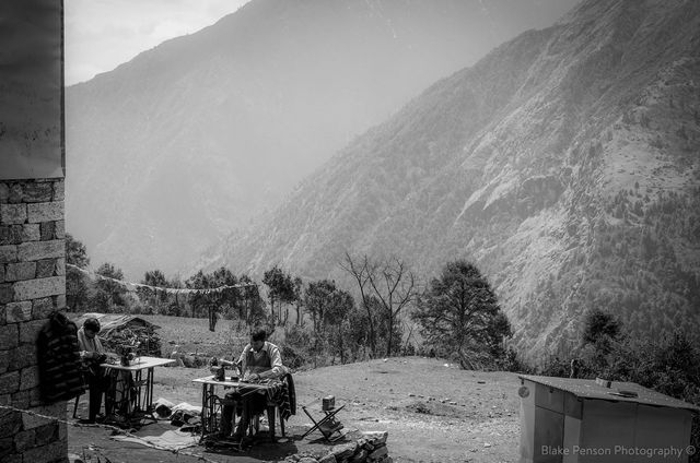 Men sewing garments in the sun