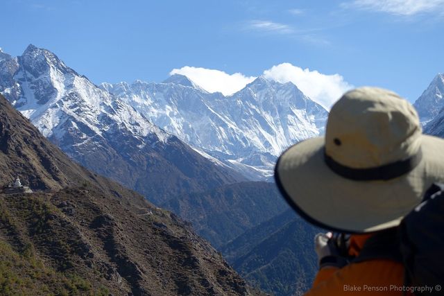 Paul taking a photo of Everest (middle left with clouds) and its neighbour Lhotse