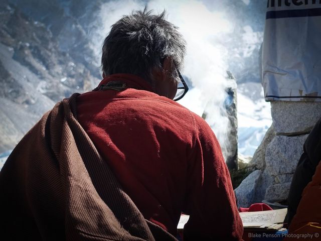 The Lama singing in front of some burning juniper leaves